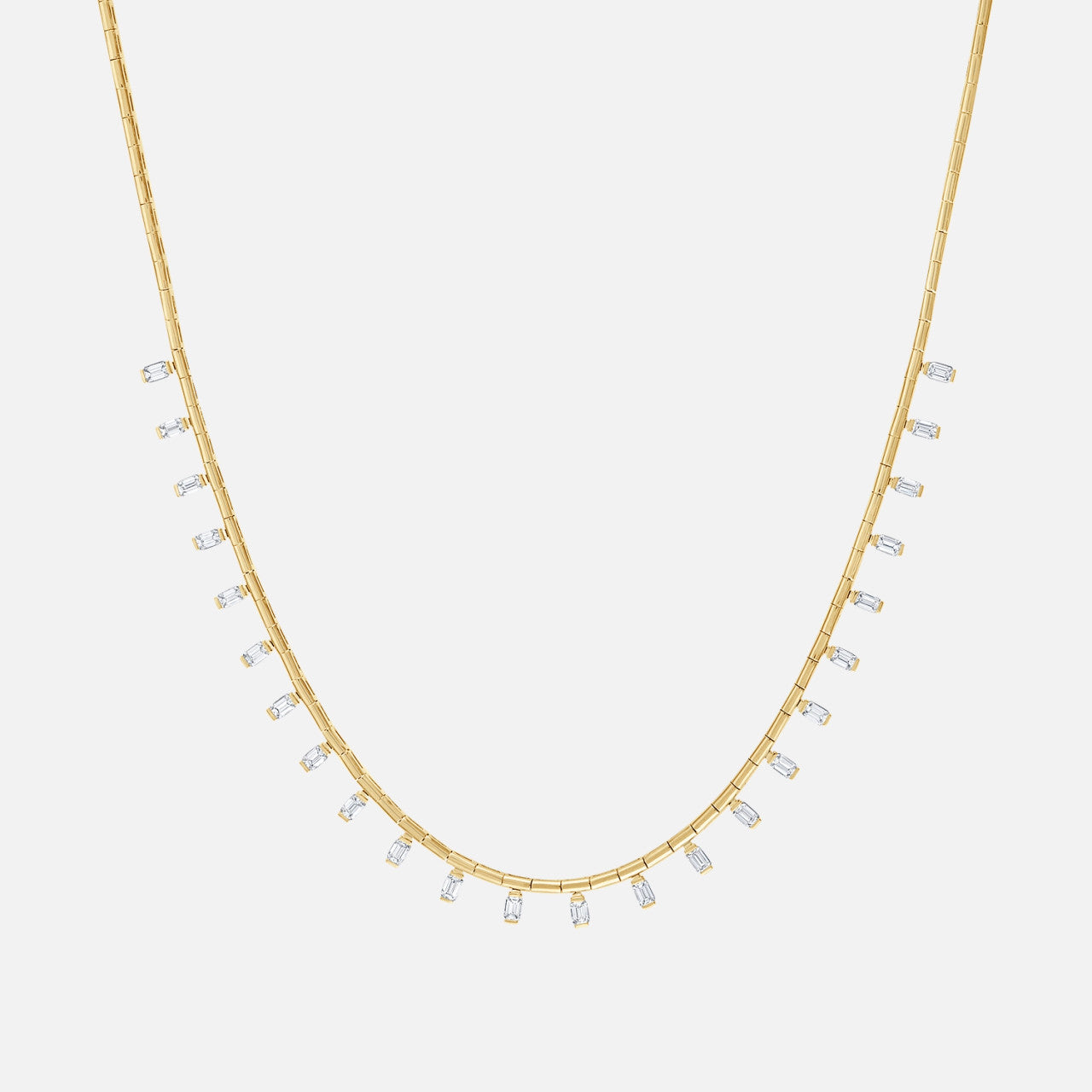 A gold necklace with emerald cut diamonds throughout the chain