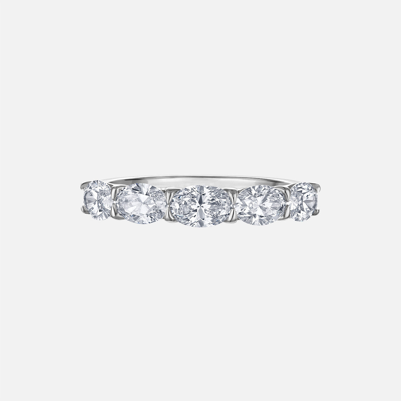 This unique east west band features five oval-shaped natural diamonds in a half eternity setting. It can be stacked with other pieces or worn alone for a stunning, classic look.