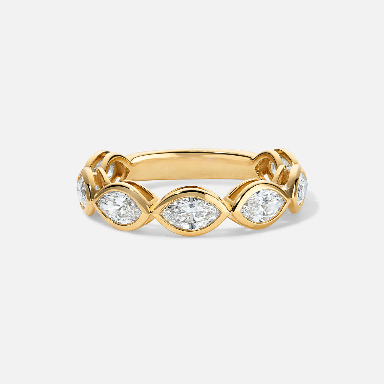 a gold ring with bezeled marquise diamonds halfway around it
