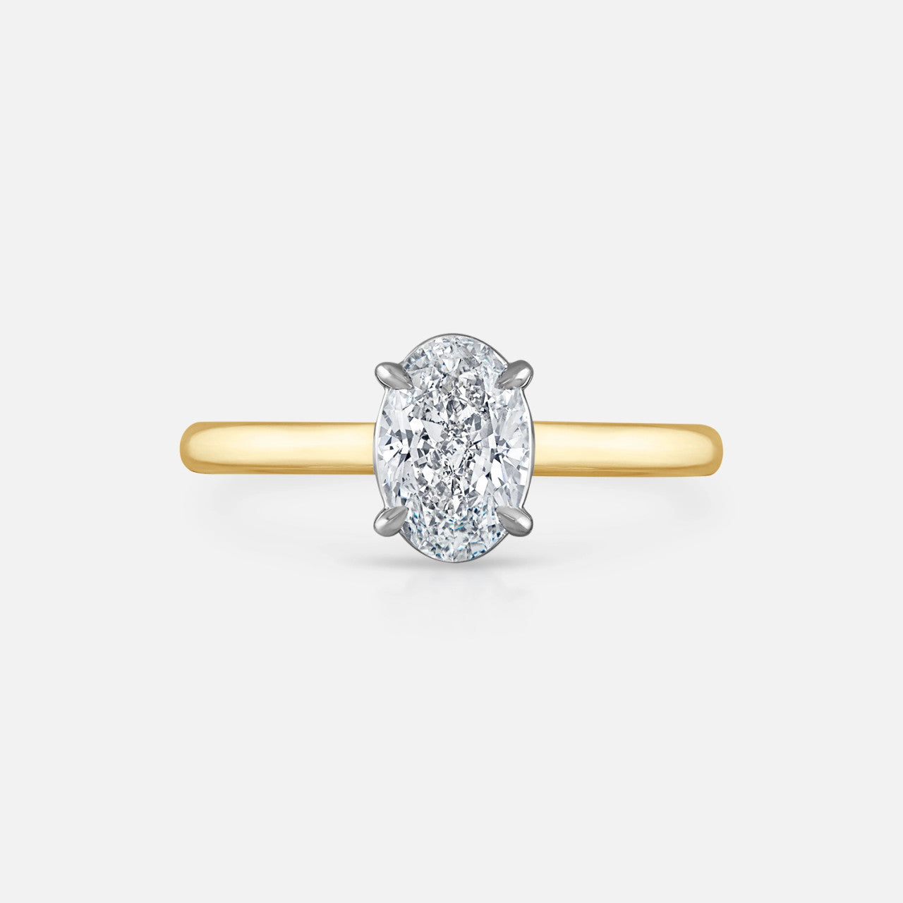 A 1.00-carat oval diamond engagement ring features an 18k solid yellow gold signature solitaire setting with platinum prongs.