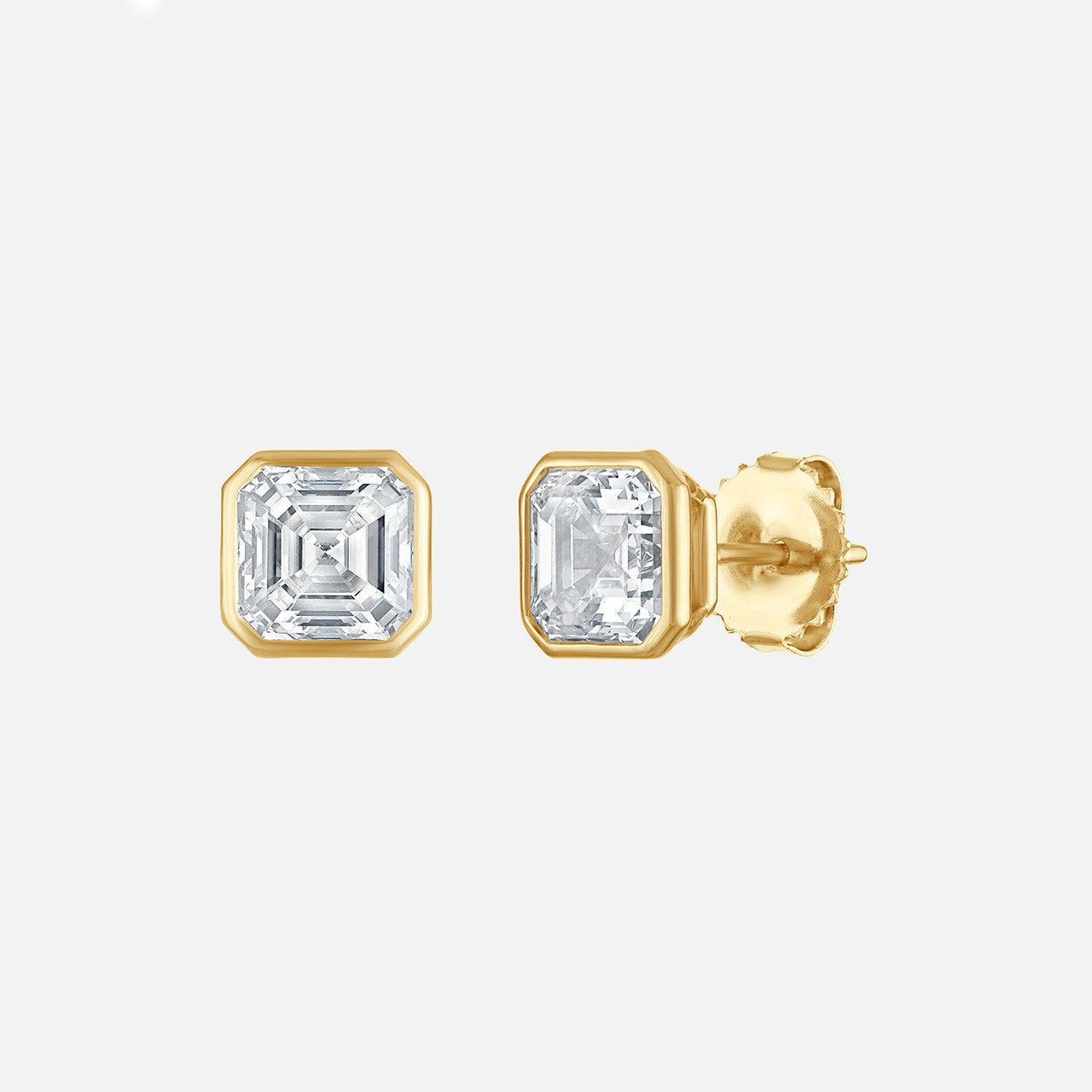Refined emerald cut diamond studs, bezel set in yellow gold