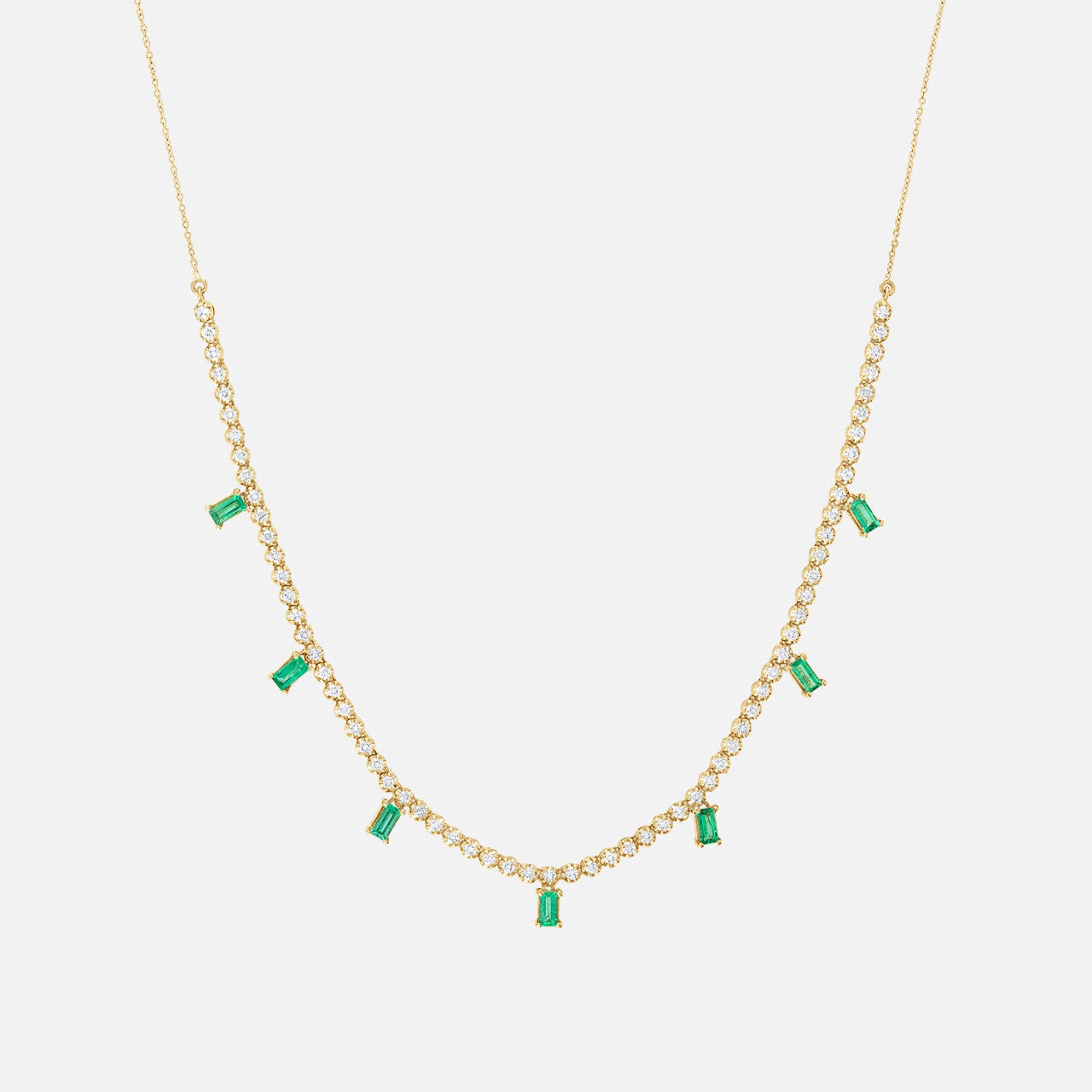 This gold necklace features seven emerald drops and 68 round natural diamonds.