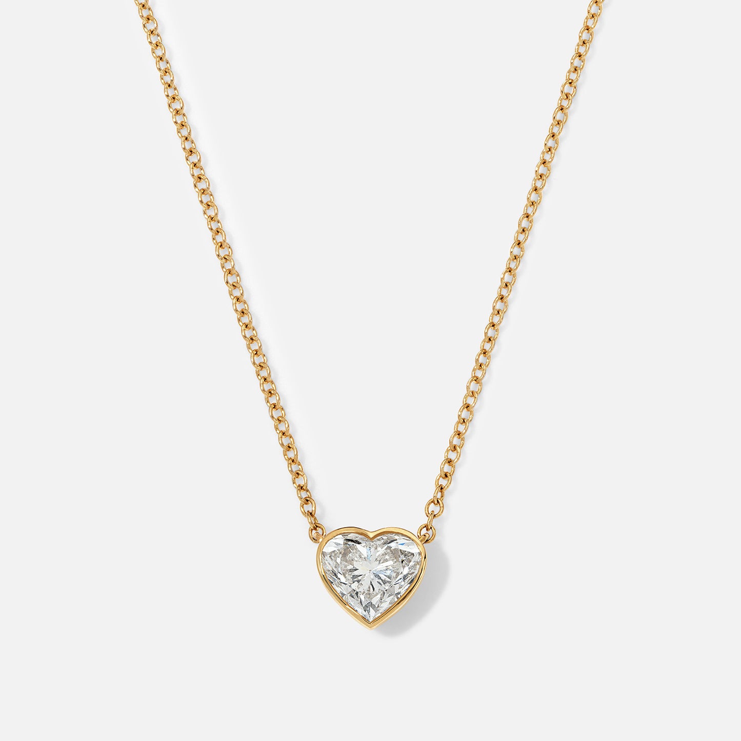 This yellow gold necklace features a heart-shaped diamond in a secure bezel setting.