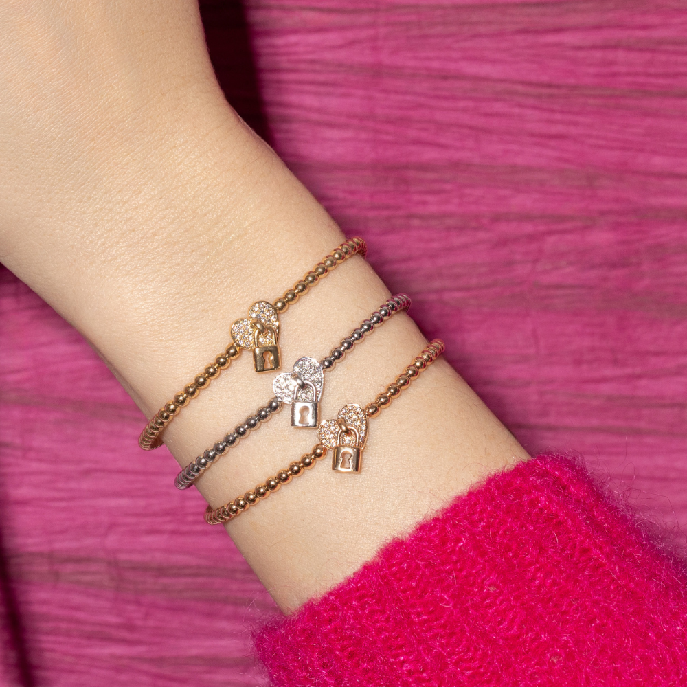 stretch bracelets with a heart in the center that contains diamonds and a small lock in front of it, shown in yellow, rose and white gold
